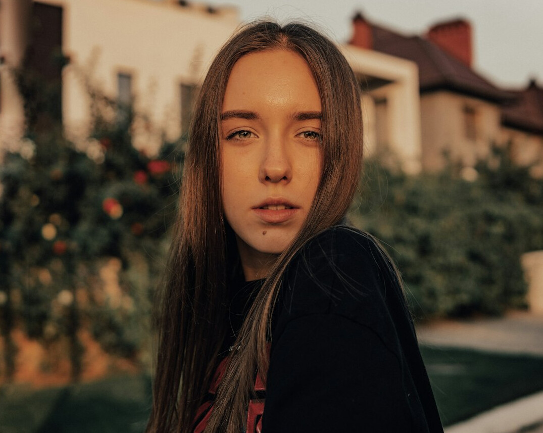 Portrait of a young woman with long hair looking at the camera